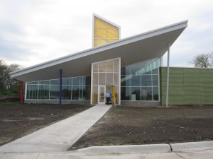 KCDC building front with dirt lawn and single sidewalk leading to the door