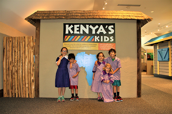 children pose in front of the Kenya's Kids sign