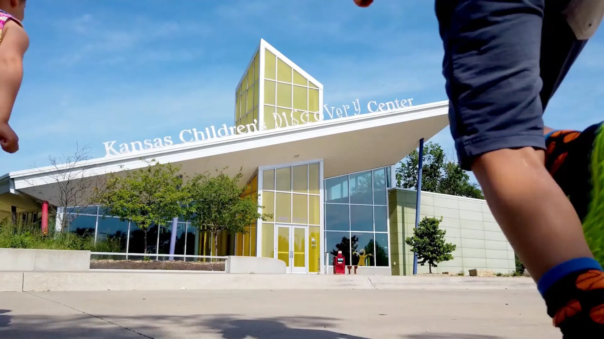 Front of building with two children entering the frame of the image.